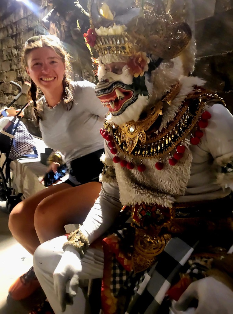 A Balinese deity statue in stone — ancient, expressive, seemingly amused by what's about to happen