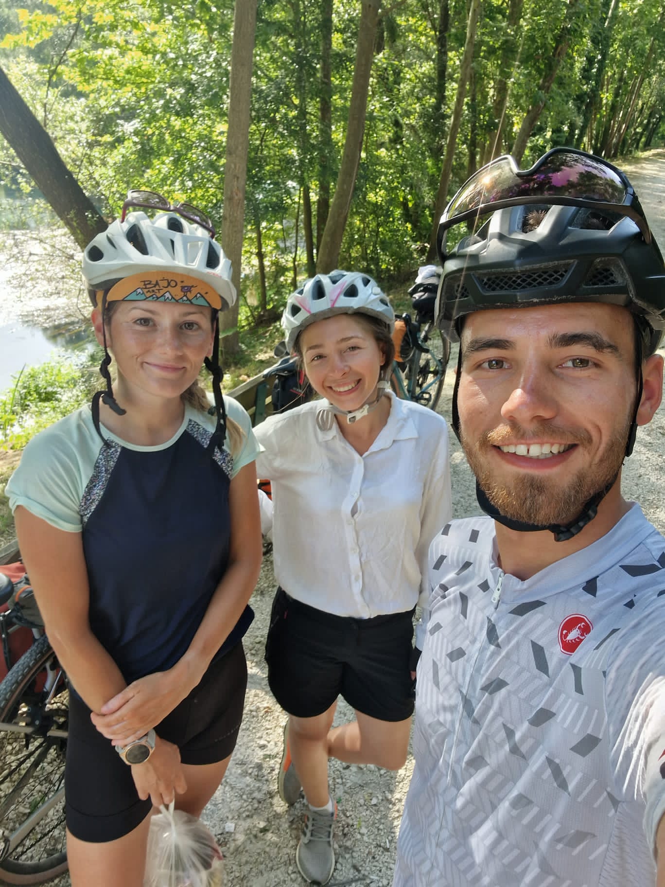 Three cyclists with loaded touring bikes on a forest road, Romania to Croatia bikepacking trip