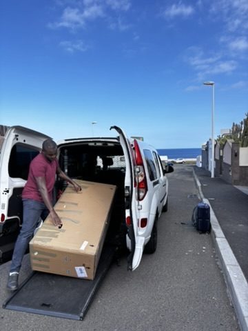 Strangers in Tenerife helping Anca with the bike — map out, pointing, a small crowd of helpful people