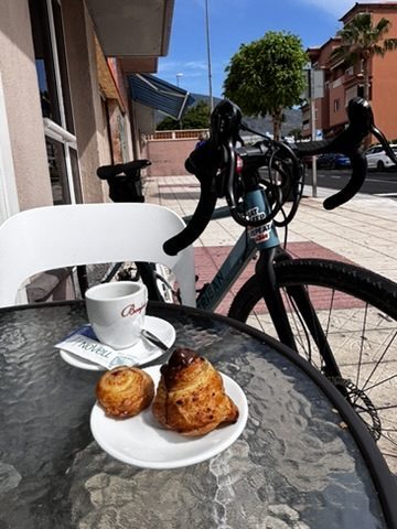 Anca off the bike at a café or viewpoint — a short, slightly guilty break from the day's riding