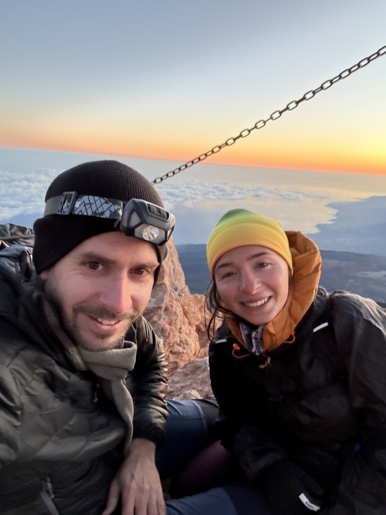 Anca and her hiking companion at the El Teide summit — wind-blown, smiling, headtorch still on