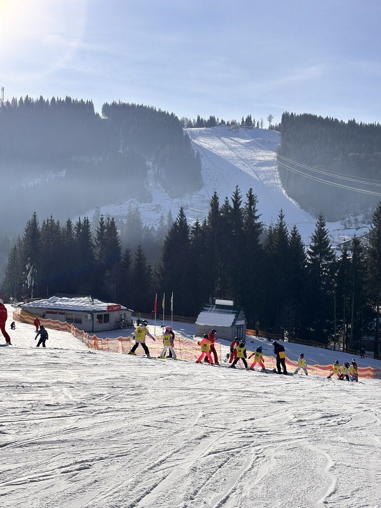Mountain ski landscape on the last day — wide slopes, blue sky, the scale of the Carpathian range visible