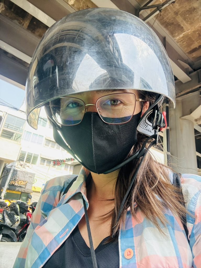Anca in a helmet on a scooter in a Thai city