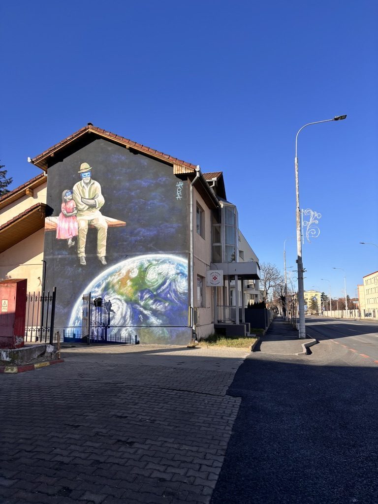 Bold colourful street art mural on a stone wall in Sibiu's old town alleys