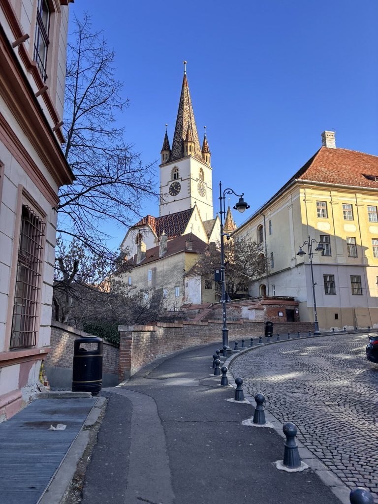 Steep cobbled street climbing through Sibiu's old town between colourful medieval buildings