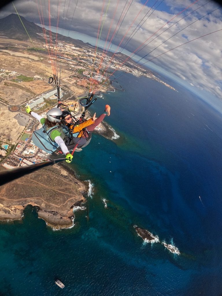 Anca paragliding above the Tenerife coast, volcanic landscape and blue Atlantic below
