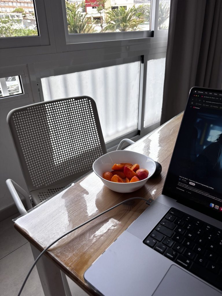 Nomad apartment setup in Tenerife — laptop open, a bowl of fresh fruit, good light, the essentials