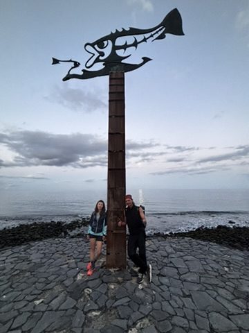 Anca and her travel buddy watching the sunset together over the Tenerife coast, warm golden light