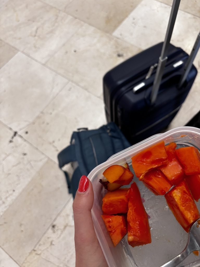 Anca at the departure point with a bag of fresh fruit from the market — one last purchase before leaving Tenerife