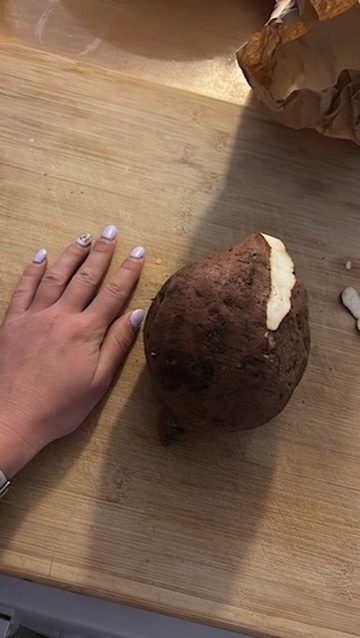 An impressively large potato being cooked in Anca's nomad kitchen in Tenerife — serious business