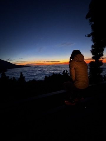 Sunset over Tenerife from a high trail — the light going golden and warm, a moment of genuine stillness and gratitude