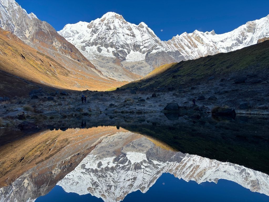 Annapurna Base Camp reflected in a mirror-still lake at dawn, Nepal